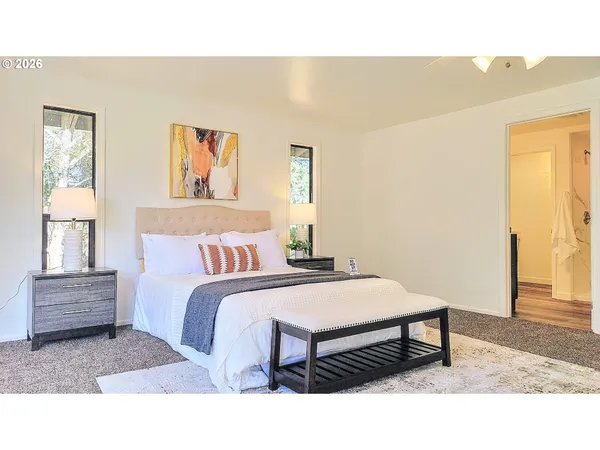a bedroom with a bed table and a window