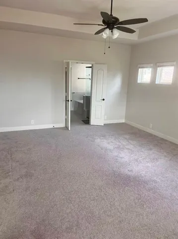 en empty room with windows and fan