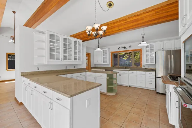 a kitchen with a refrigerator a sink and dishwasher with a large kitchen next to a window