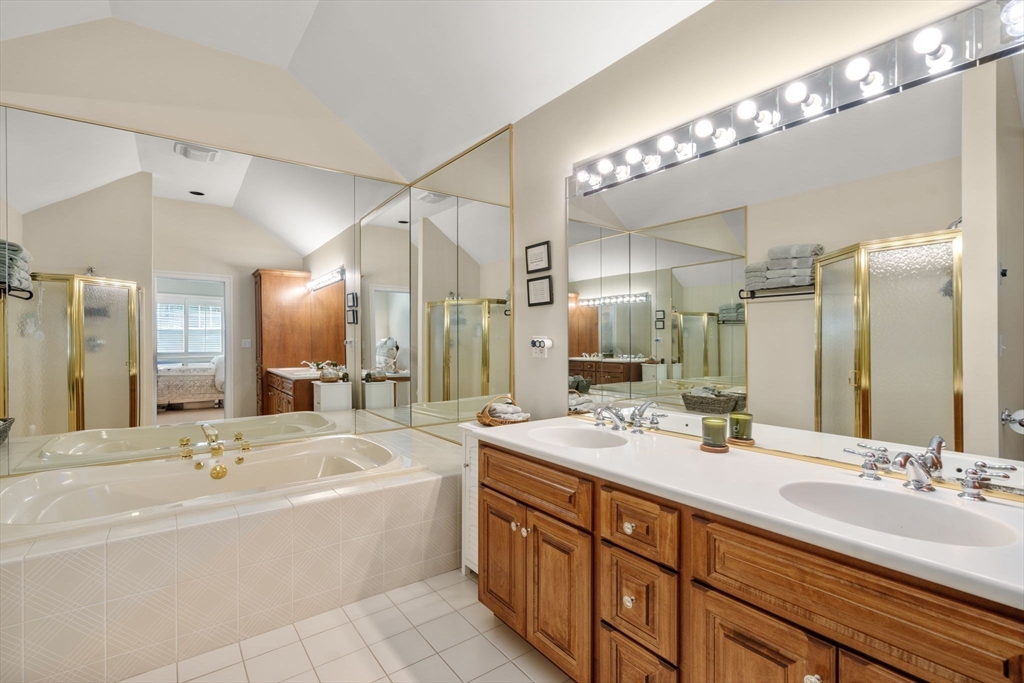 9 Highcroft Way, Unit 9 Hopkinton, MA 01748 - Photo 16 of 22 a bathroom with a tub a double vanity sink and a mirror