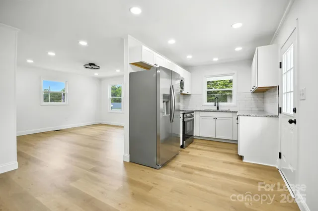 a kitchen with stainless steel appliances a refrigerator sink and cabinets