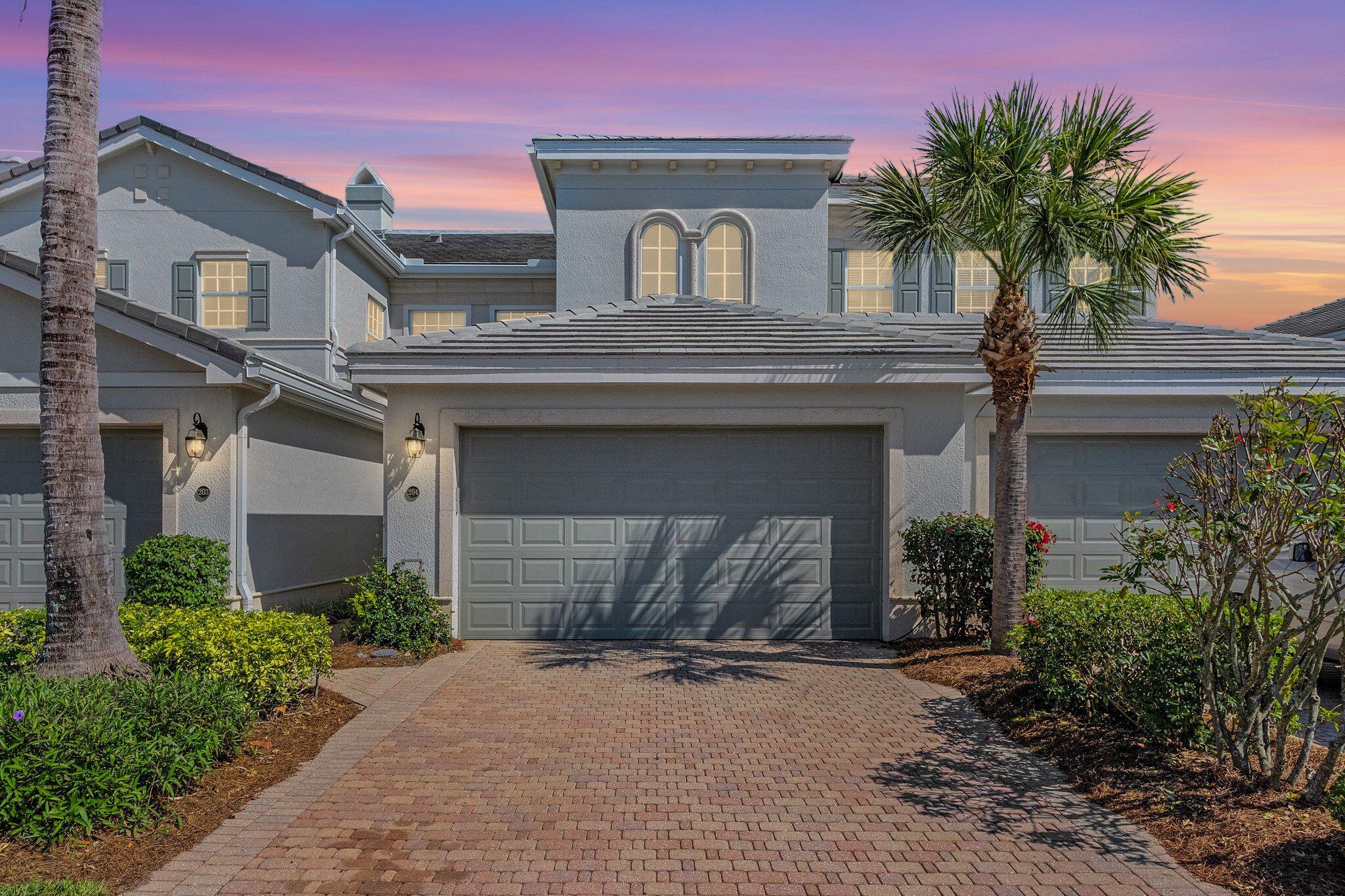 9283 Museo Circle, Unit 204 Naples, FL 34114 - Photo 2 of 23 a front view of a house with garage and plants