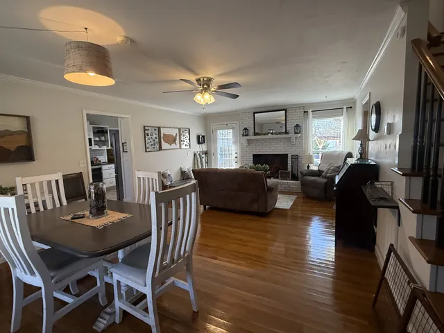 a view of a dining room with furniture a chandelier and wooden floor
