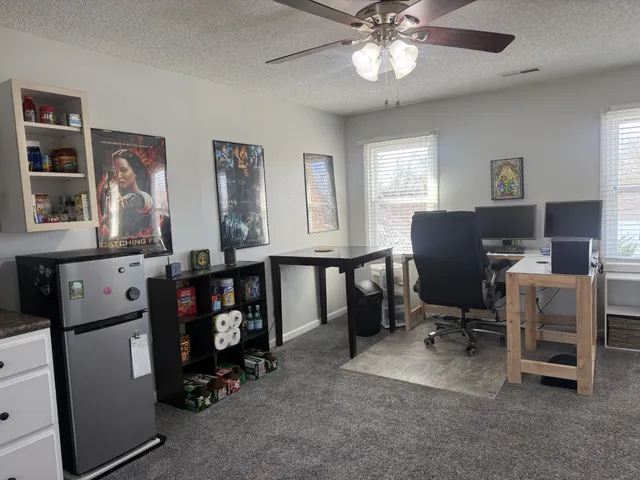 a view of a workspace with furniture and a window