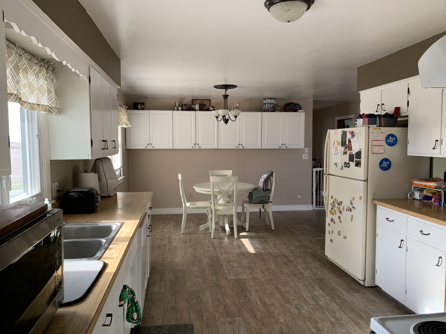 11624 Highway 17 Bonfield, IL 60913 - Photo 4 of 14 a kitchen with stainless steel appliances a stove top oven a sink a dining table and chairs with wooden floor