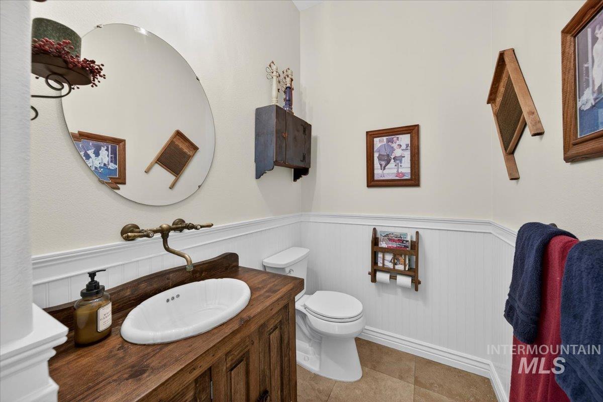414 East Shafer View Drive Meridian, ID 83642 - Photo 14 of 50 Guest/Powder 1/2 Bathroom featuring an antique wood vanity with an oval basin sink, wall-mounted brass faucet, and a large circular mirror