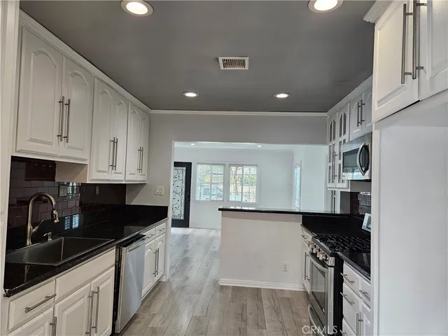 a kitchen with granite countertop a sink a stove and cabinets
