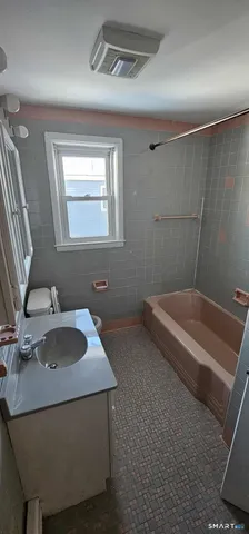 a bathroom with a granite countertop sink a toilet and mirror