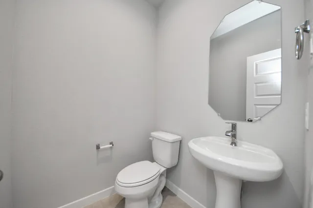 a bathroom with a sink toilet and a mirror