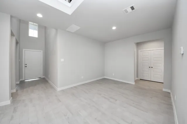 a large white kitchen with stainless steel appliances kitchen island a sink dishwasher a stove and a refrigerator with wooden cabinets