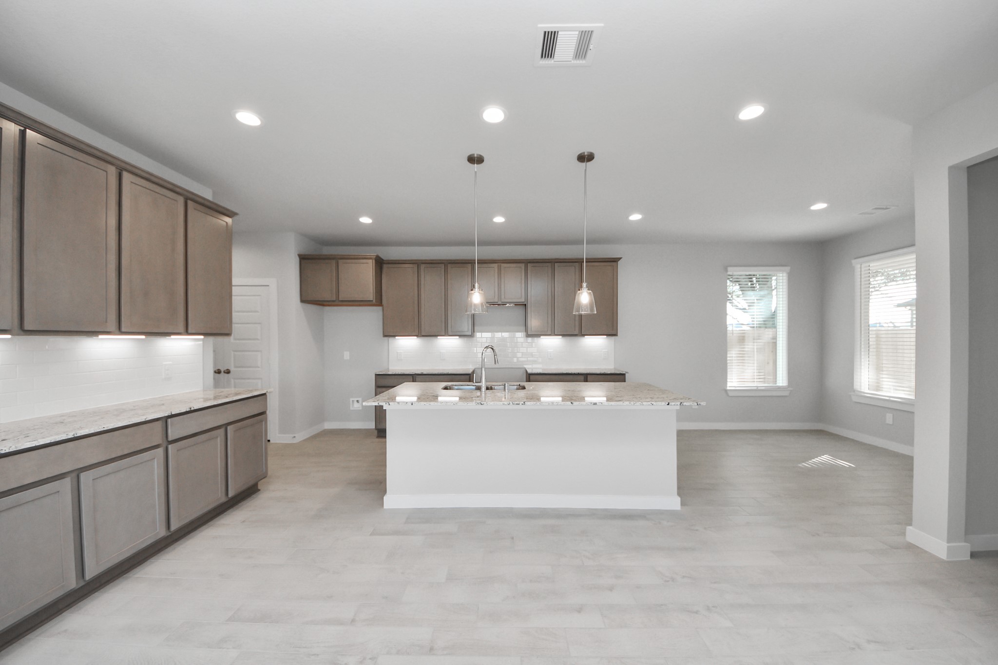 15807 Telge Ridge Lane Cypress, TX 77429 - Photo 10 of 45 a large white kitchen with stainless steel appliances kitchen island a sink dishwasher a stove and a refrigerator with wooden cabinets