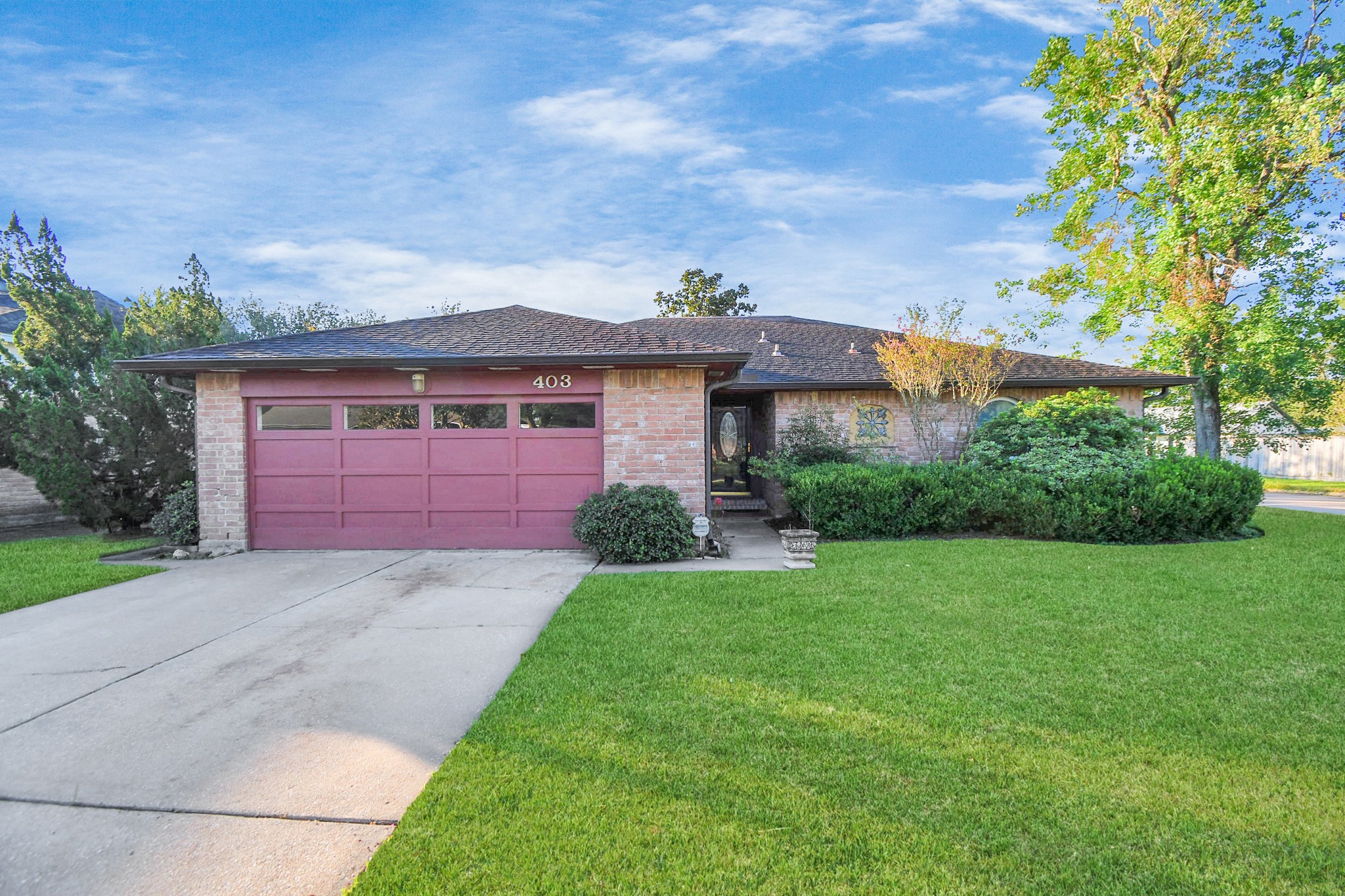 403 Westwood Drive Friendswood, TX 77546 - Photo 1 of 38 a front view of a house with a garden and trees