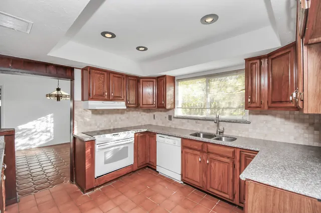 a kitchen with stainless steel appliances granite countertop wooden cabinets a sink and a stove