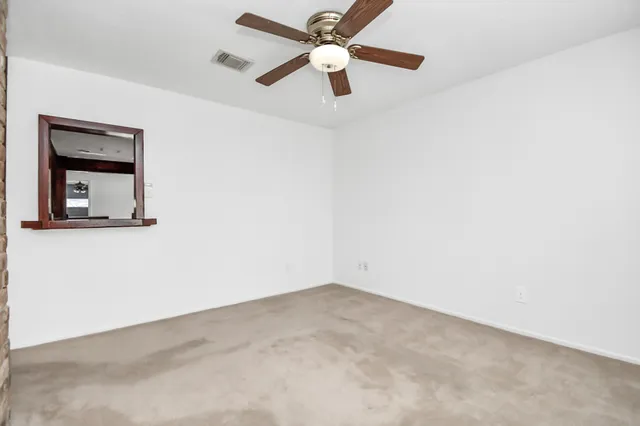 an empty room with a window and a ceiling fan