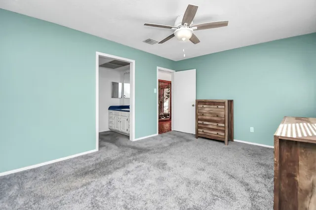 an empty room with furniture and a ceiling fan