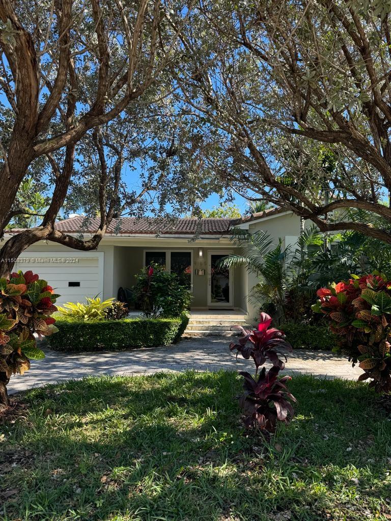 a view of a house with backyard sitting area and garden