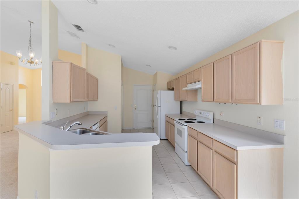 3640 Sickle Street Orlando, FL 32812 - Photo 6 of 21 a kitchen with stainless steel appliances a sink dishwasher stove refrigerator and cabinets