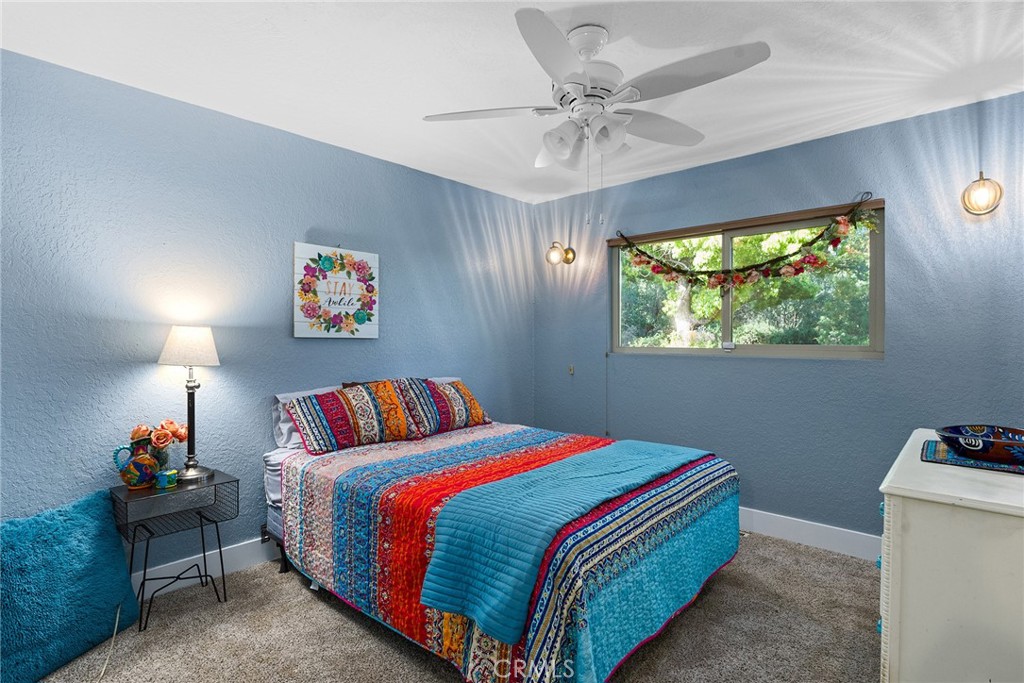 32 Mission Olive Road Oroville, CA 95966 - Photo 25 of 52 a bedroom with a bed and a chandelier