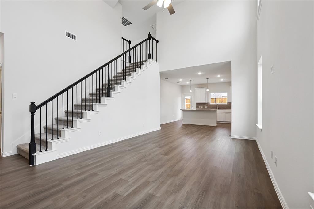 3900 Coco Lane Sherman, TX 75090 - Photo 6 of 40 Unfurnished living room featuring dark wood-type flooring, ceiling fan, sink, and a towering ceiling