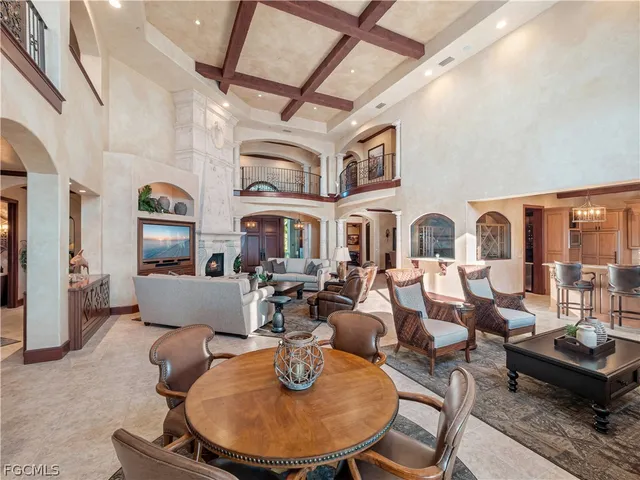 a living room with fireplace lots of white furniture and a rug