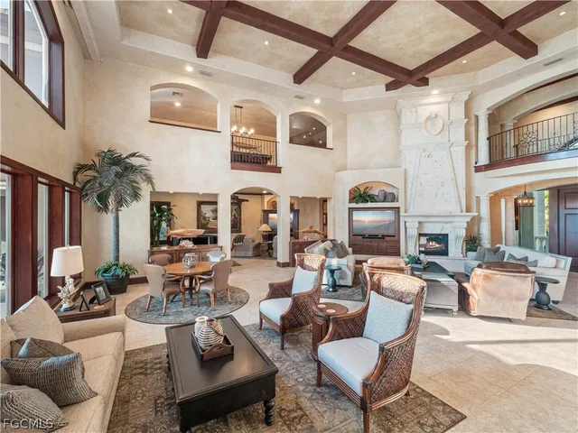 a living room with furniture a fireplace and potted plants