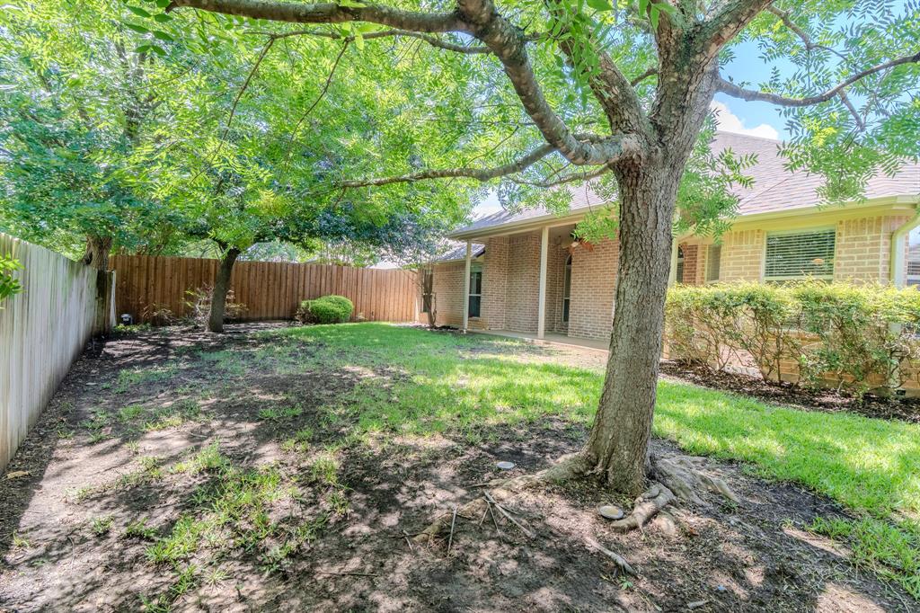 6014 Brenhaven Road Arlington, TX 76017 - Photo 3 of 18 Expansive backyard featuring mature trees, a manicured lawn, and privacy fencing