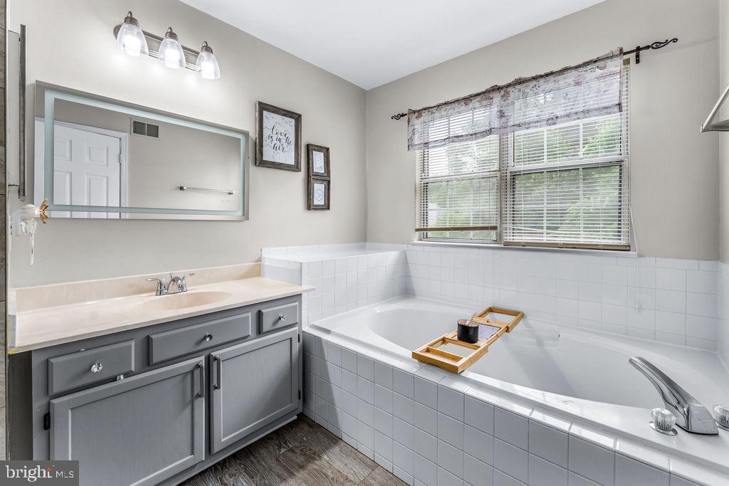 11409 Hermosa Drive Laurel, MD 20708 - Photo 17 of 28 a bathroom with a tub sink and mirror