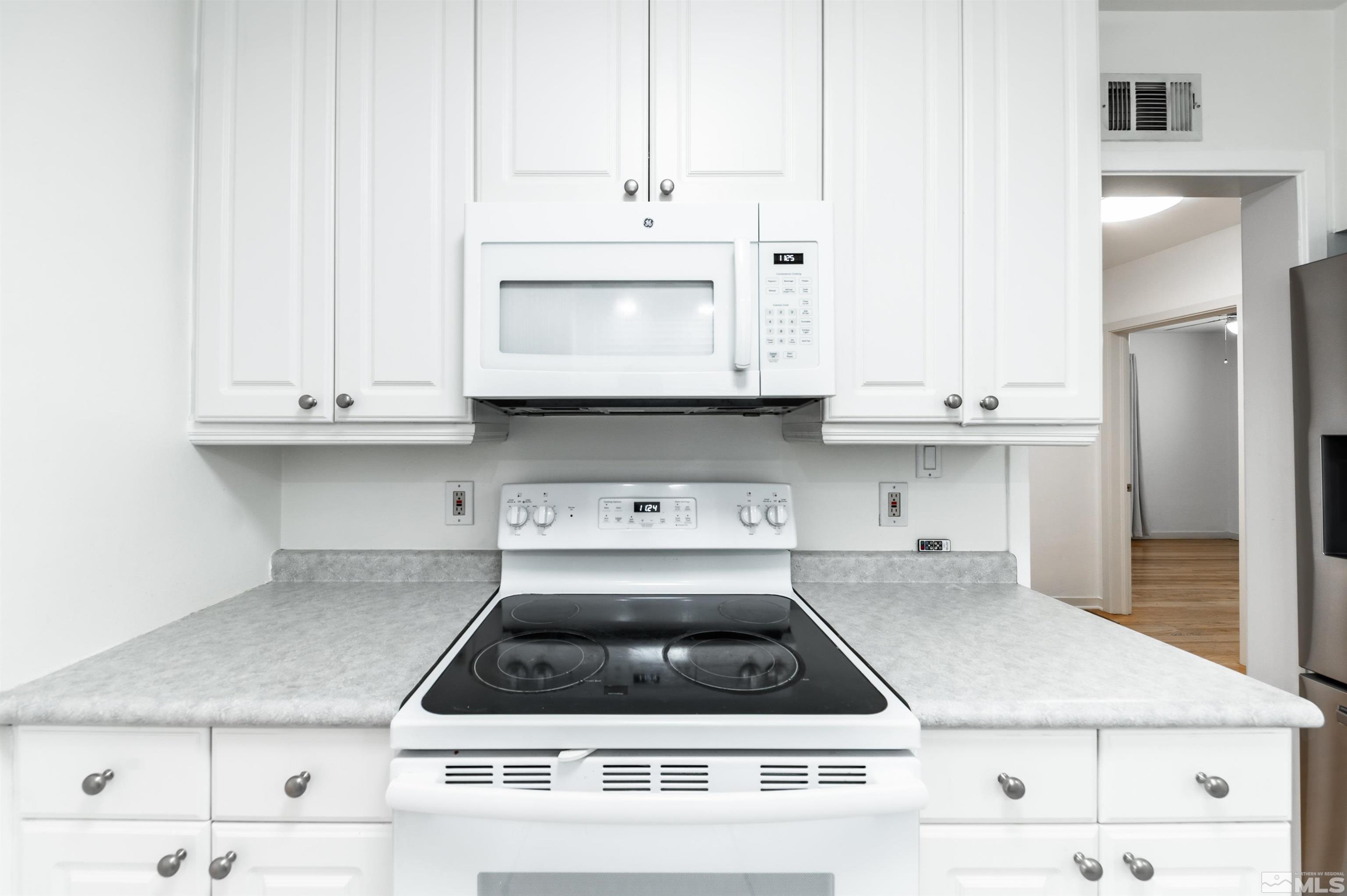 17 Linwood Place Reno, NV 89509 - Photo 17 of 36 a kitchen with granite countertop white cabinets and white appliances
