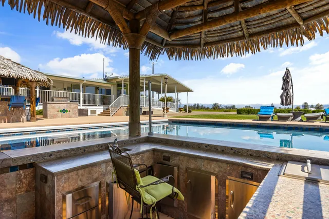 a roof deck with table and chairs a barbeque with potted plants