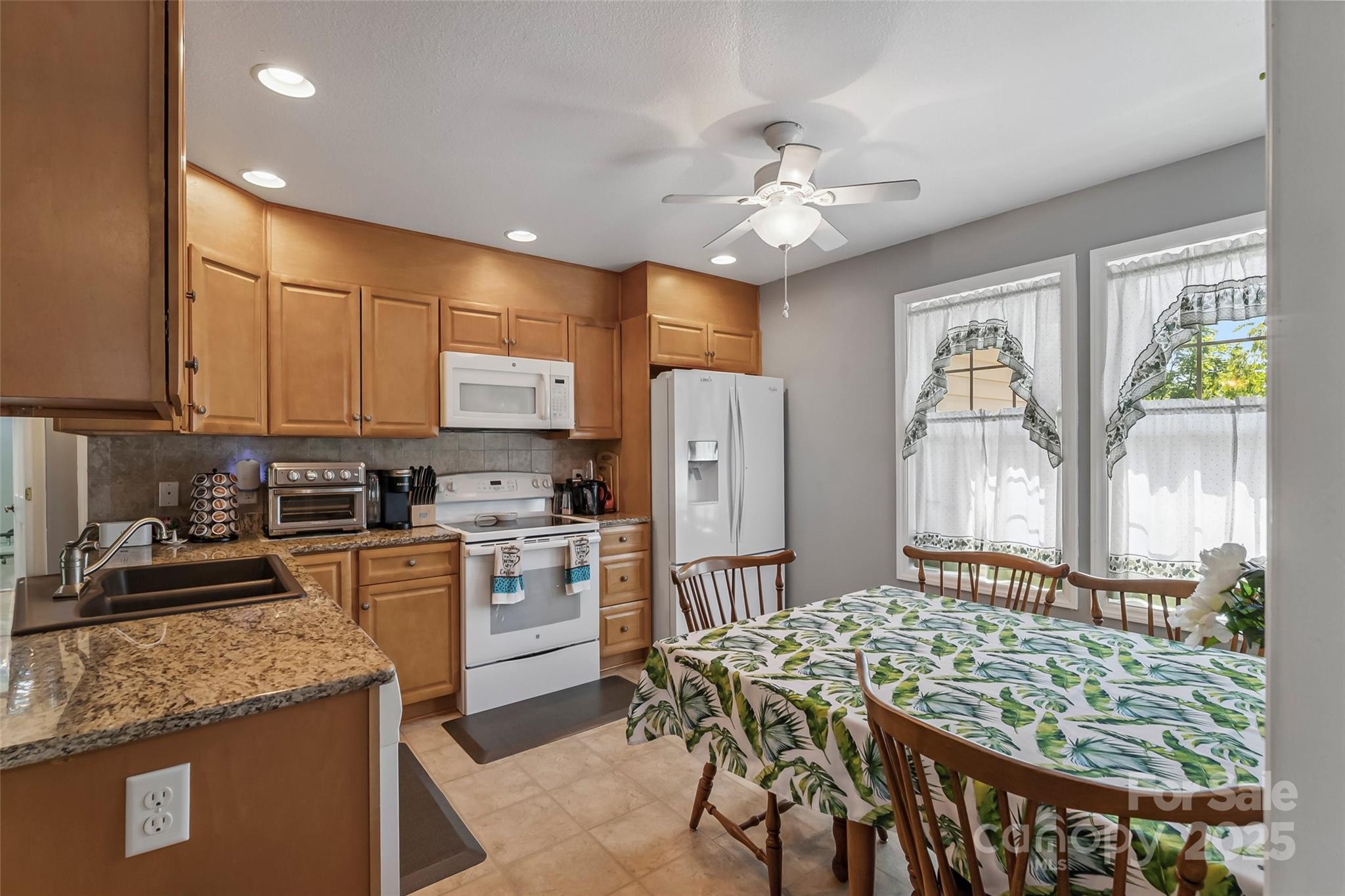 862 Asbury Road Candler, NC 28715 - Photo 4 of 18 a kitchen with sink a refrigerator and chairs