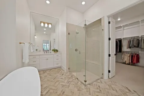 a spacious bathroom with a glass door shower and a sink