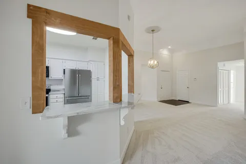 an empty room with a window and a kitchen