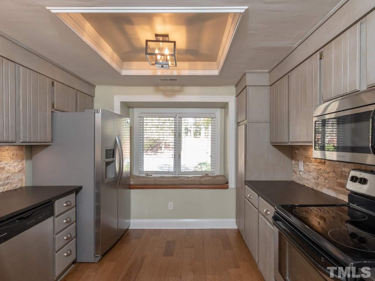 4407 Sunscape Lane Raleigh, NC 27613 - Photo 4 of 29 a kitchen with stainless steel appliances granite countertop a stove and a refrigerator
