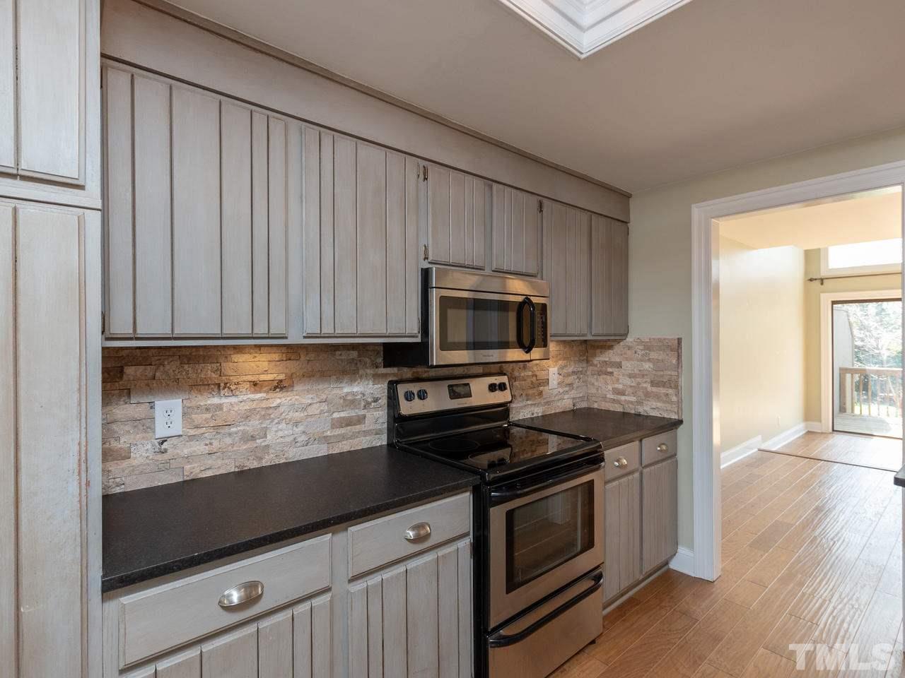 4407 Sunscape Lane Raleigh, NC 27613 - Photo 5 of 29 a kitchen with stainless steel appliances granite countertop a stove a microwave and a sink
