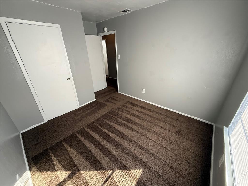 1714 Short Street, Unit D Cleburne, TX 76033 - Photo 8 of 9 Neutral gray wall paint, brown carpet flooring, white trim, and white interior doors