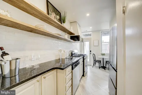 a kitchen with granite countertop a sink a stove and cabinets