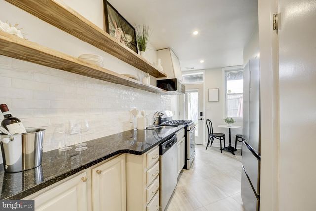 a kitchen with granite countertop a sink a stove and cabinets