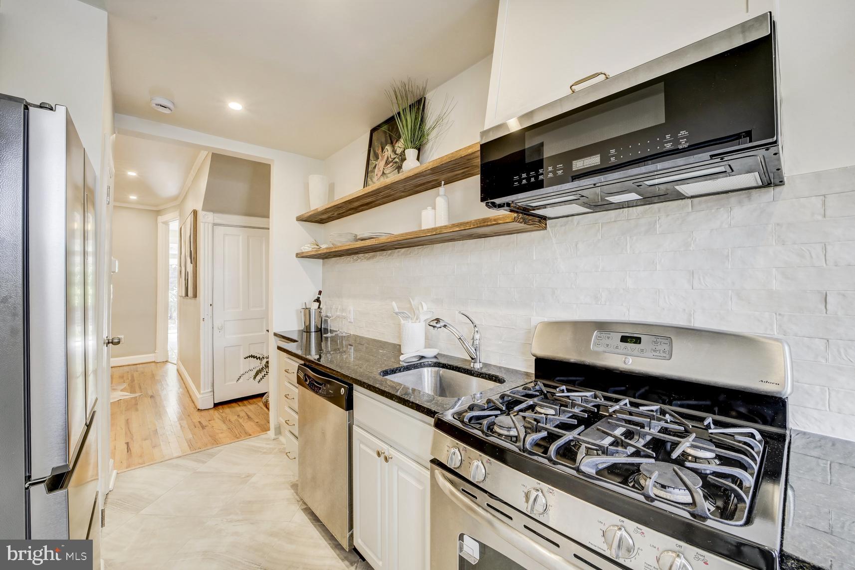 1823 4th Street Northwest Washington, DC 20001 - Photo 15 of 48 a kitchen with stainless steel appliances granite countertop a sink stove and refrigerator