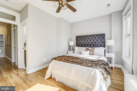 a bedroom with a bed and wooden floor