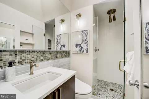 a bathroom with a sink toilet vanity and shower