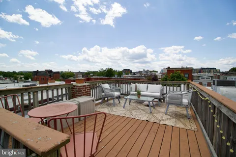 a view of a balcony with wooden floor and outdoor seating