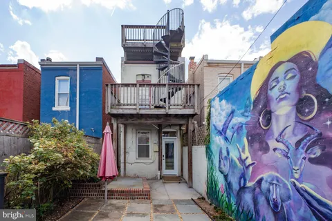 a view of large building with a bench and trees