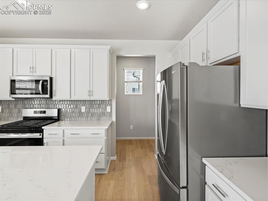 10648 Waterloo Drive Peyton, CO 80831 - Photo 11 of 36 a kitchen with granite countertop a refrigerator and a stove top oven