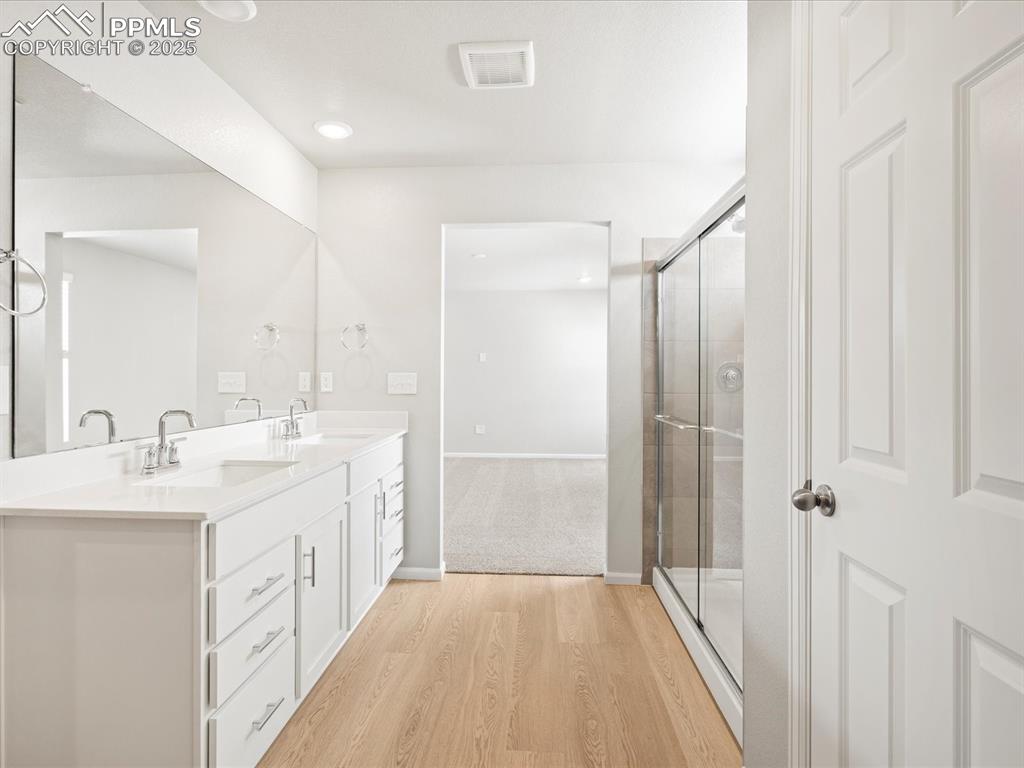 10648 Waterloo Drive Peyton, CO 80831 - Photo 26 of 36 a bathroom with a double vanity sink and mirror