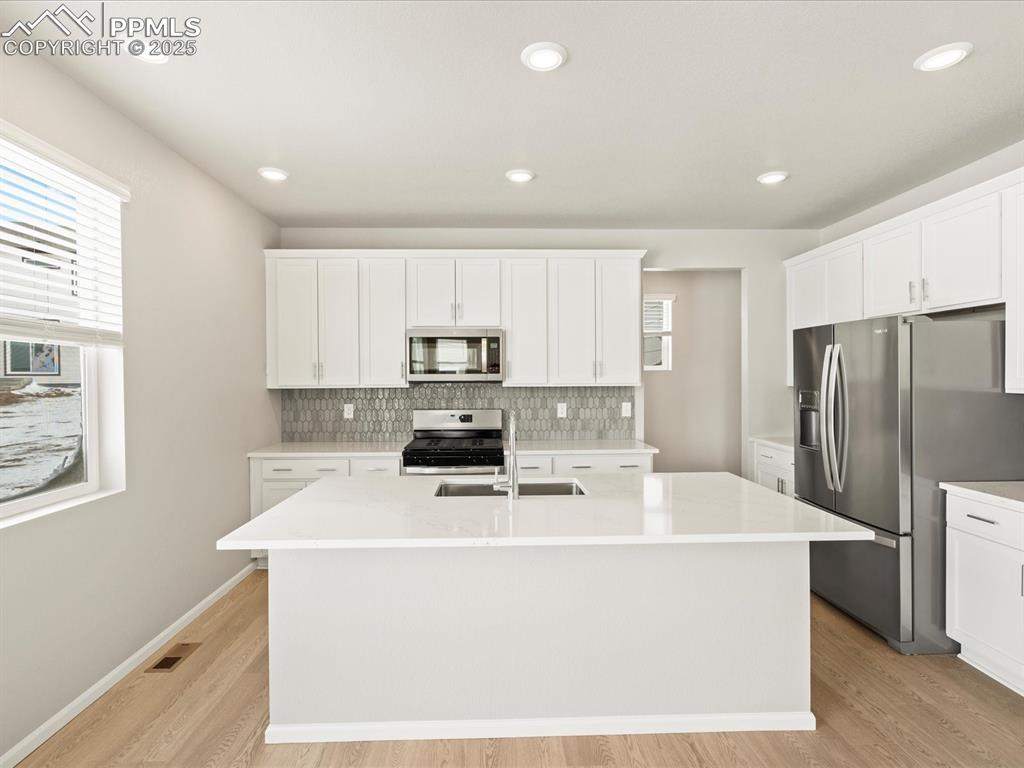 10648 Waterloo Drive Peyton, CO 80831 - Photo 4 of 36 a kitchen with stainless steel appliances a refrigerator sink stove and microwave