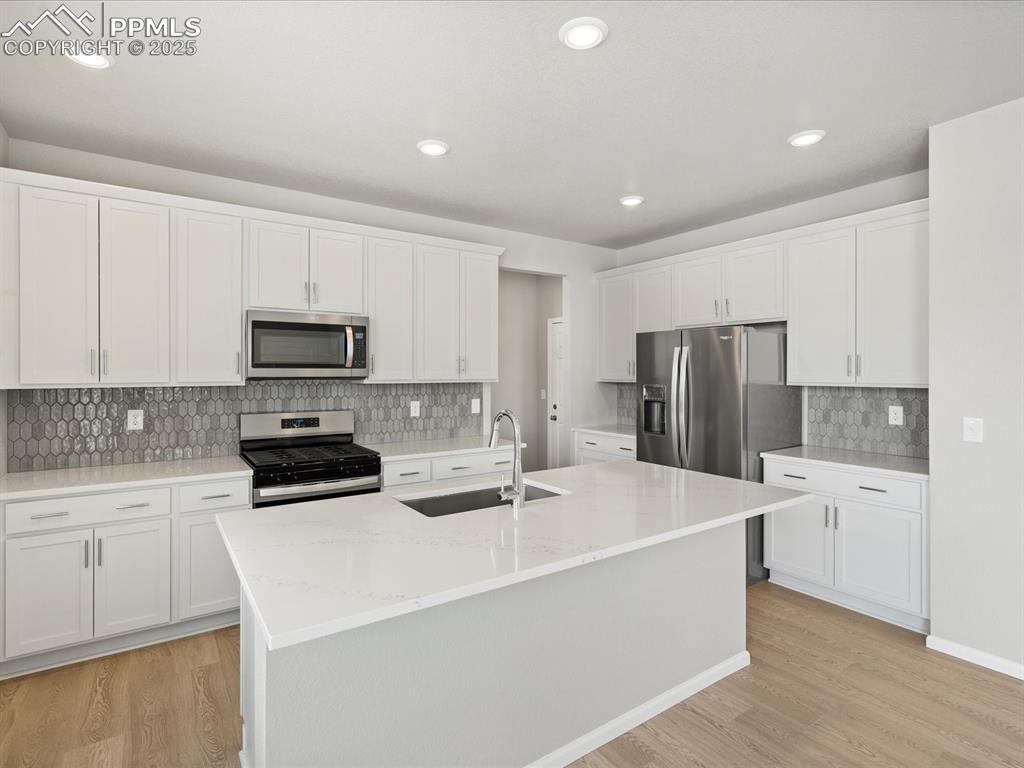 10648 Waterloo Drive Peyton, CO 80831 - Photo 7 of 36 a kitchen with stainless steel appliances a refrigerator sink stove and white cabinets