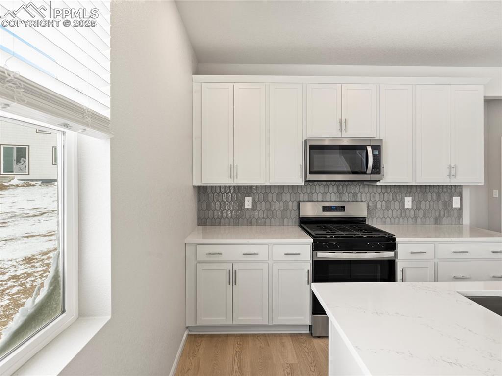 10648 Waterloo Drive Peyton, CO 80831 - Photo 8 of 36 a kitchen with white cabinets and stainless steel appliances