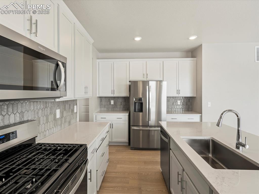10648 Waterloo Drive Peyton, CO 80831 - Photo 9 of 36 a kitchen with refrigerator a stove top oven and sink