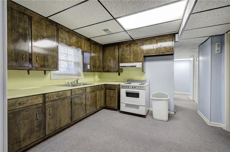 408 Mac Johnson Road Northwest Cartersville, GA 30121 - Photo 46 of 65 a large white kitchen with a sink and dishwasher a stove top oven with wooden floor