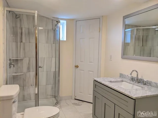a bathroom with a granite countertop sink toilet and shower